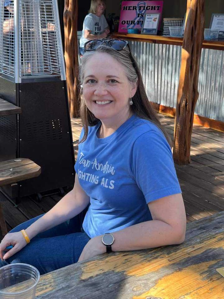 Community member smiling at an outdoor table