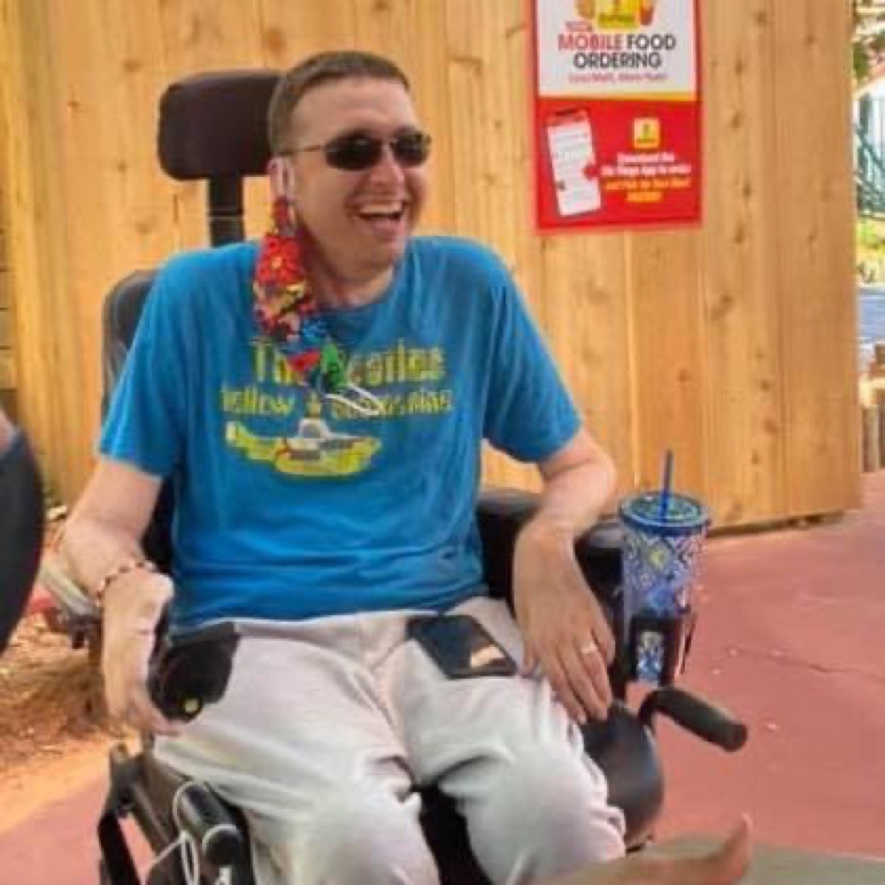 Community member laughing in a power wheelchair